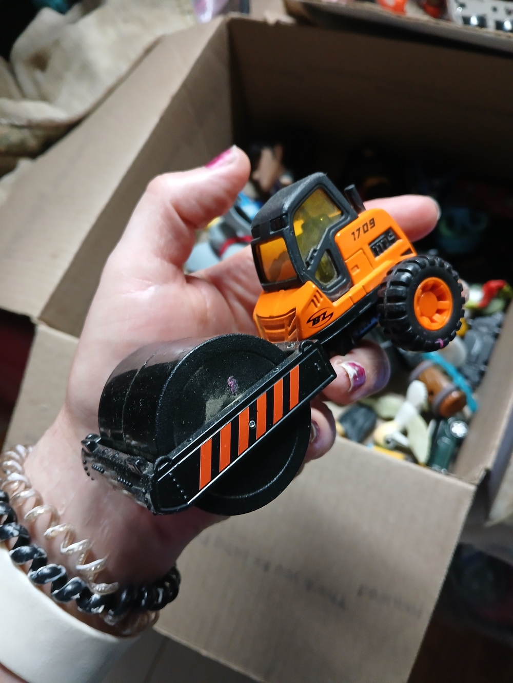 die-cast orange road roller toy Maisto